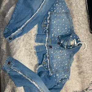 Cropped denim jacket with a button-up front, chest pockets